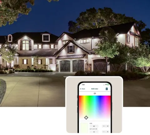 A phone showing the Luxor lighting app in front of a lit house