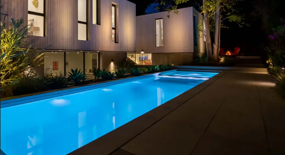 FX Luminaire modern fixtures lighting a long pool and the house beside it at dusk (FX Luminaire product photograph)