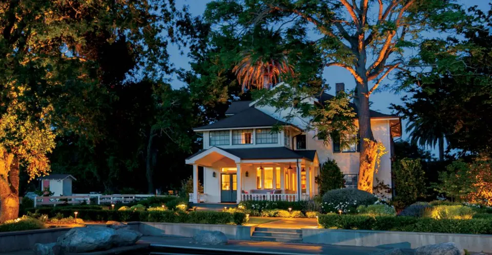 FX Luminaire fixtures lighting a cottage-style house and garden at dusk (FX Luminaire product photograph)