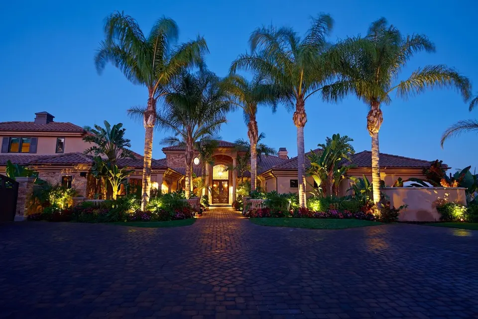 An estate at blue hour with LED lighting on the facade and palms