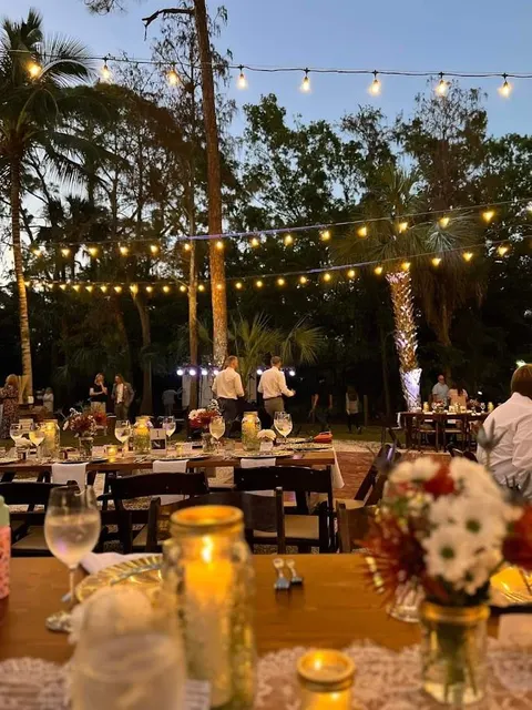 Dinner tables set outdoors at night under strings of warm lights